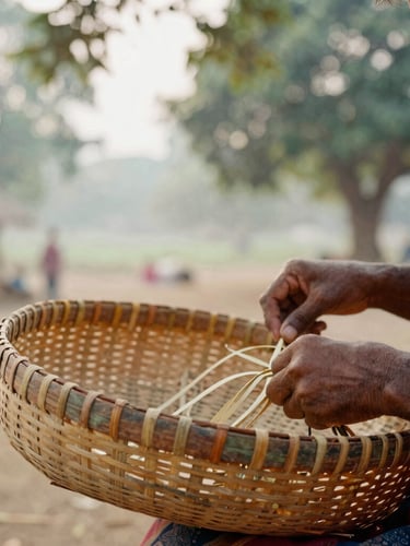 A close-up of hands weaving a bamboo basket in a rural Indian village setting, soft morning light filtering through trees, authentic craftsmanship, 35mm lens.