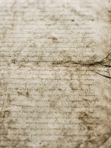 Close-up of an old, weathered archival document with faint text, illuminated by soft natural light, matte texture, desaturated earth tones, scholarly documentary photography, 35mm, bleeding to the right edge.