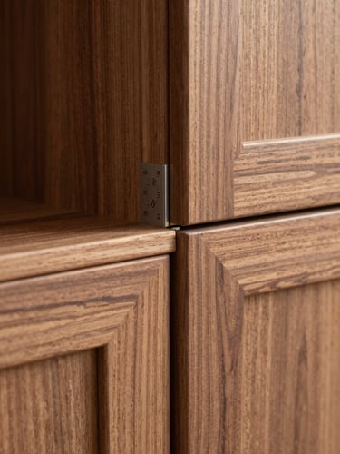 Close-up detail of a custom walnut wardrobe miter joint, showing millimeter-precise wood-to-metal alignment. Natural, crisp daylight highlighting the tactile grain.