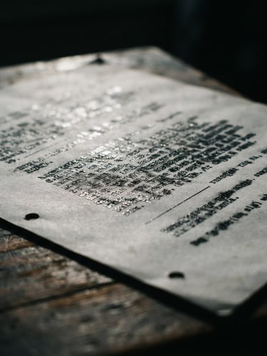 Moody close-up of a physical typed screenplay page under dramatic low-key window light, silver highlights, rich shadows, 35mm film grain