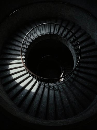 Minimalist psychological thriller poster, a stark architectural staircase winding down into absolute darkness, dramatic shadow play, anamorphic lens, 35mm film grain.