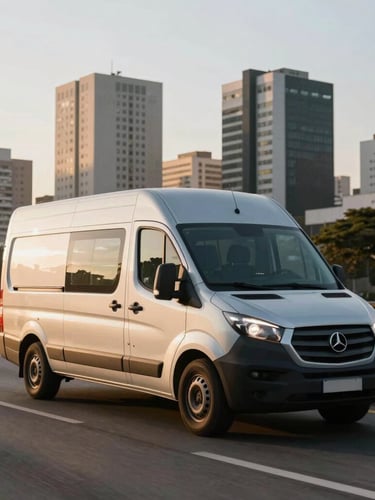 Wide environmental shot of a modern silver cargo van moving along Marginal Pinheiros in São Paulo during early morning golden hour, clean urban backdrop.