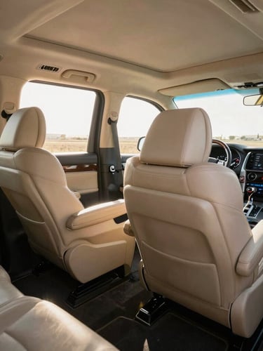Wide-angle interior shot of a luxury multi-utility vehicle cabin, spotless beige leather seats with generous legroom, bright morning sunlight streaming through clean windows, professional dashboard visible.