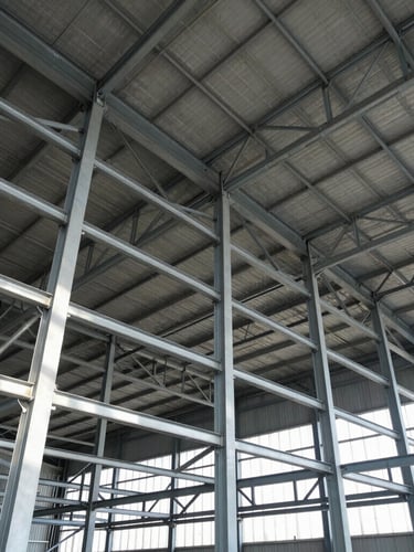 Low angle shot of a completed industrial warehouse interior, massive steel framework, emphasizing height and metallic textures, crisp architectural photography.