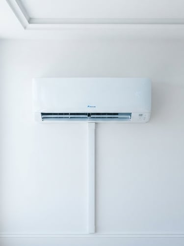 Clean, newly installed white minisplit unit on a pristine white wall, straight-on symmetrical shot, bright indoor light, sharp focus, crisp blue and white tones.