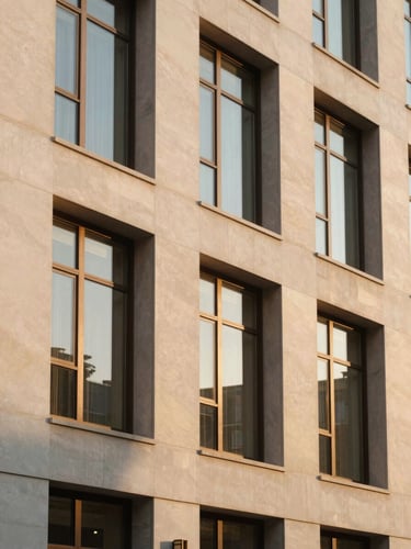 Warm architectural shot of a grand hotel facade with clean mid-century lines, golden hour sunlight reflecting off tall bronze-framed windows.
