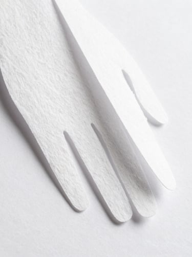 Macro detail of a hand-cut paper sculpture, side-angle capturing the physical depth, layered cotton paper, soft natural side-light casting subtle shadows, pure white background