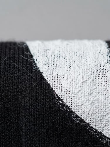 Macro shot of screen printing ink curing on a high-quality black cotton t-shirt, bright high-key studio lighting, sharp focus on fabric texture, clean gray backdrop