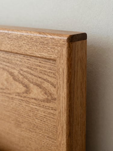 Macro photograph of a hand-sanded timber joint on a bespoke headboard, soft natural side-lighting, rich textured oak grain, shallow depth of field, 35mm