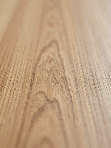 Extreme macro shot of raw hand-sanded English oak grain, soft natural side-light, shallow depth of field, warm editorial 35mm photography