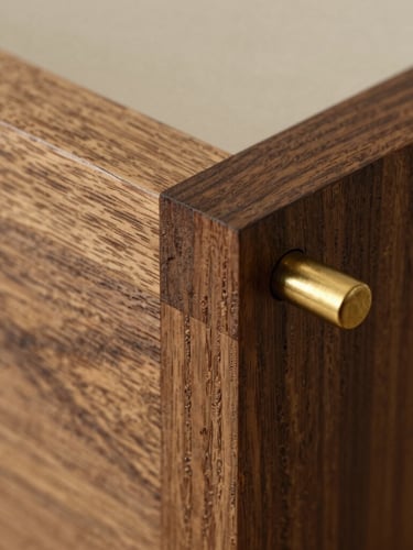 A vertical macro crop of a mortise and tenon joint in dark smoked oak, showcasing the seamless alignment of fibers and hand-finished bronze pin, warm side-lighting