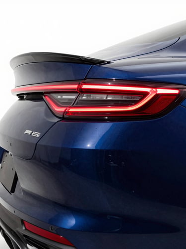 Low-angle vehicle profile in a high-contrast studio, sharp linear LED reflections showing perfect panel curves, technical navy blue shadows, 35mm