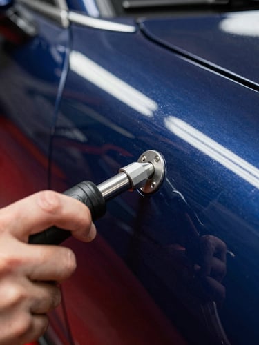 Extreme close-up of a technician's hand using a specialized PDR tool under sharp linear LED reflection lines on a flawless navy blue car panel, 35mm