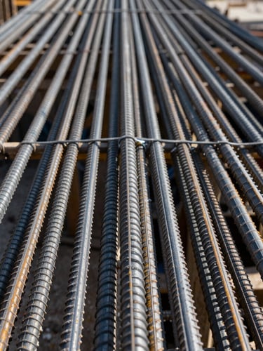 Macro shot of perfectly tied reinforcement steel on a residential construction site, straight-on geometric angle, sharp contrast, daylight