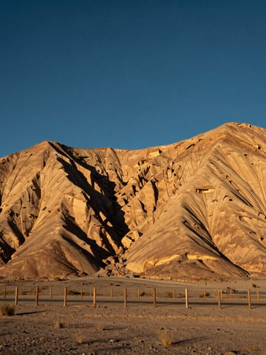 Wide panoramic Utah high-desert landscape at golden hour, sandstone cliffs in the background, a well-maintained fence line in the foreground, crisp high-desert daylight, deep navy and sandstone tones, sharp architectural focus