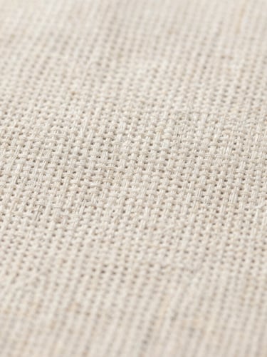 Macro close-up of raw linen fabric showing detailed weave and thread count under clean, natural daylight, high-contrast texture