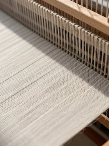 Macro close-up of raw linen fibers being woven on a modern loom, bright natural daylight, high-resolution texture details