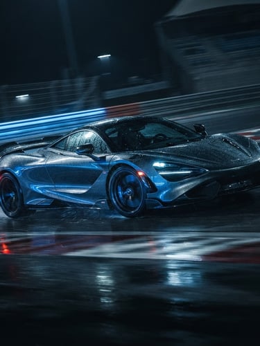Low-angle dynamic rolling shot of a modern supercar on a wet racetrack, dramatic low-key lighting with electric blue reflections, cinematic anamorphic lens