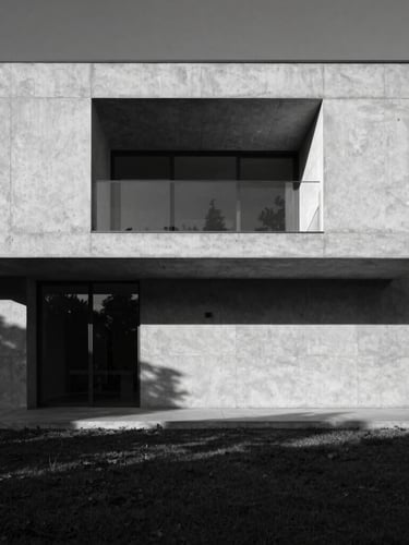 High-contrast black and white architectural photography of a minimalist concrete villa facade, dramatic late afternoon sun casting deep geometric shadows, wide-angle symmetrical composition, Hasselblad medium format.