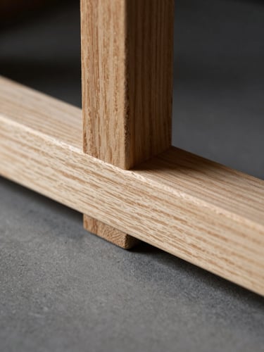 Macro shot of a precise wood joinery connection, clean oak timber, dark background, dramatic side-lighting highlighting the wood grain texture, sharp focus