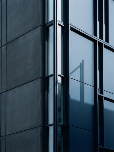 Minimalist architectural photography with clean vertical lines, cool diffused daylight, sharp shadows, deep navy tones, 35mm.