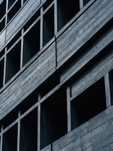 Minimalist macro shot of a structured architectural concrete facade with clean lines and sharp shadows under cool daylight, high-contrast, 35mm