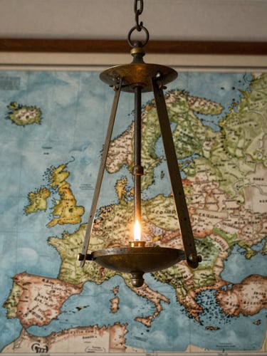 Vue rapprochée d'un pendule en laiton ancien suspendu au-dessus d'une carte de l'Europe centrale, éclairée par la lueur d'une bougie unique, ambiance clair-obscur.