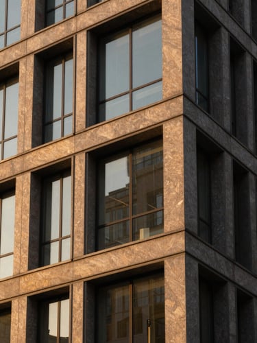 Structured modern office building facade with clean geometric lines, warm directional sunlight, rich amber tones, sharp focus