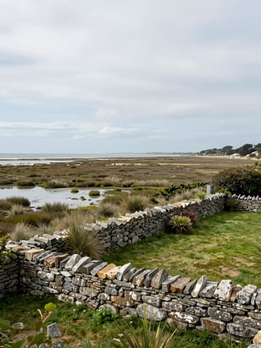 Wide panoramic Atlantic coastline at Île de Ré, a stone-walled private garden in the right foreground, salt marshes receding to the left horizon, overcast soft light, no people, no structures beyond a low wall