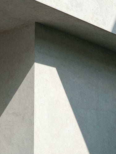 Macro close-up of a sharp geometric shadow falling across a concrete architectural structure, bright high-contrast natural light, minimalist 35mm photography
