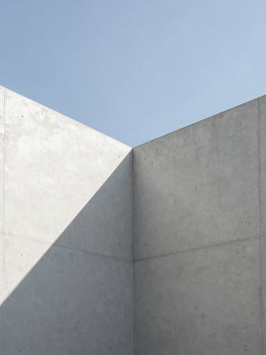 Minimalist architectural photography, clean concrete lines meeting a sharp sky, stark high-contrast natural light with deep shadows, 35mm