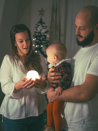 sesion fotografia de una familia en su casa en navidad jugando con una luz
