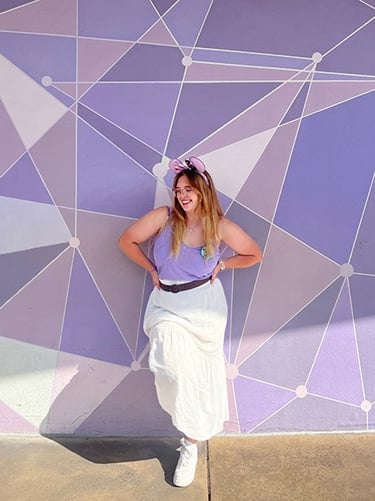 Ameliah Knopp pictured in front of the Purple Wall at Disney's Magic Kingdom® Park.