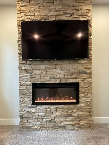 Wall-mounted TV above stone fireplace built by At Hand Heroes in Glendale AZ