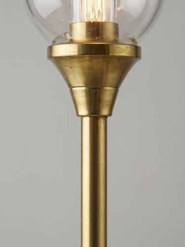 Macro detail shot of a brushed brass floor lamp joint and hand-blown glass shade, clean industrial lighting, 35mm