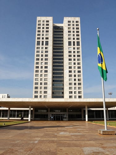 Wide-angle view of a modern civic government building entrance in Brasília, Brazilian flag visible to the right side, clean institutional architecture under bright mid-morning daylight, documentary framing
