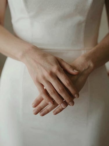 Candid close-up of two hands gently holding during a quiet wedding moment, soft natural light, linen textures