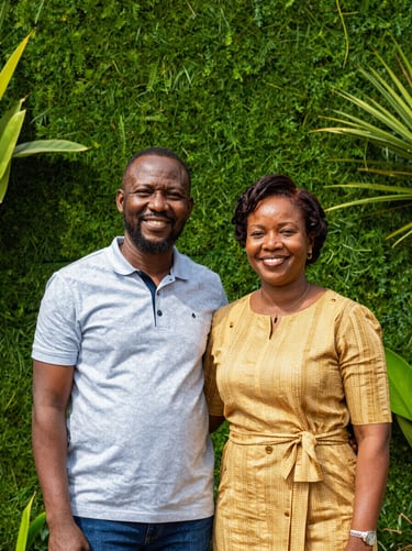 Warm outdoor portrait of a smiling Gabonese man and woman, founders, standing in front of a modern green wall, bright natural daylight, professional yet authentic, 35mm.
