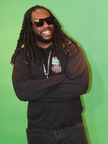 a man with dreadlocks and sunglasses on a green background