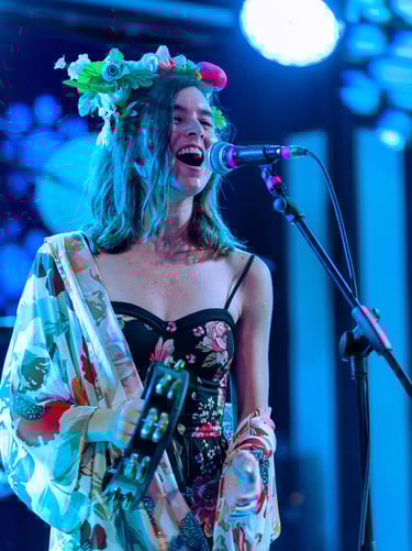 a woman in a floral dress singing into a microphone
