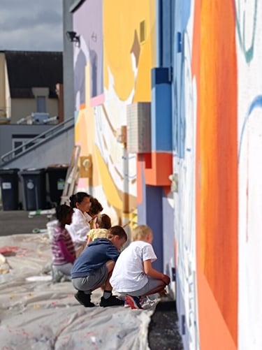 students painting on the wall