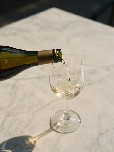 A close-up of natural wine being poured into a delicate glass on an outdoor marble table, warm sun-drenched afternoon light, 35mm film aesthetic.