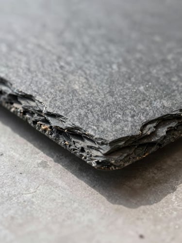 Extreme close-up of a slate raised floor panel edge detail on a job site, showing the natural cleavage texture and precision-cut seam under north-facing indoor daylight, no people, no showroom