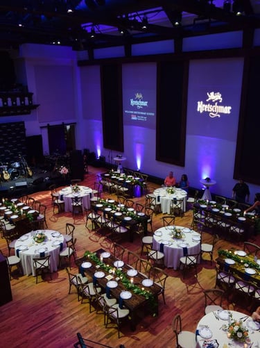 a large room with tables and chairs and a stage