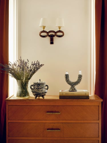 Commode vintage avec céramiques et luminaires chinés, moulures haussmanniennes et rideaux colorés