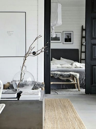 Interior decorado con tonos negros y blanco, distribuidor y dormitorio