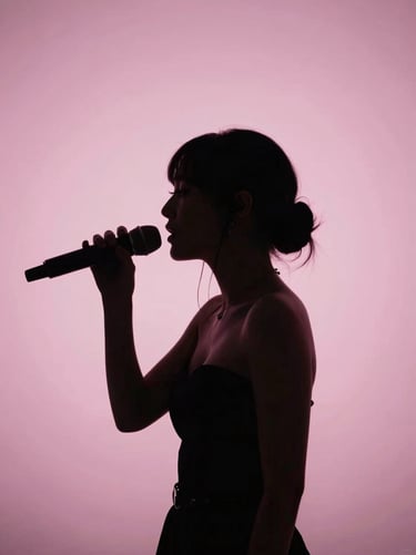 A silhouette of a singer with a sophisticated hairstyle against a softest pink backlit background in a North American / US theater, exuding timeless grace and mystery.