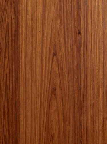 Vertical crop of Honduran mahogany grain, showing the tight, uniform fibers under a hand-rubbed oil finish.