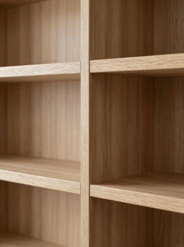 Close-up of bespoke millwork, clean wood joints of a built-in library shelf, warm natural oak texture, soft side lighting