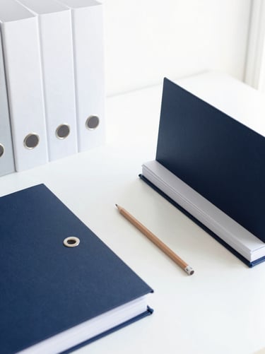Meticulous workspace with structured office files, high-quality stationery, and a single short pencil, bright north-facing daylight, minimalist editorial photography